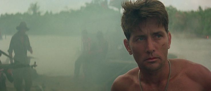 a shirtless man with earphones standing in the fog