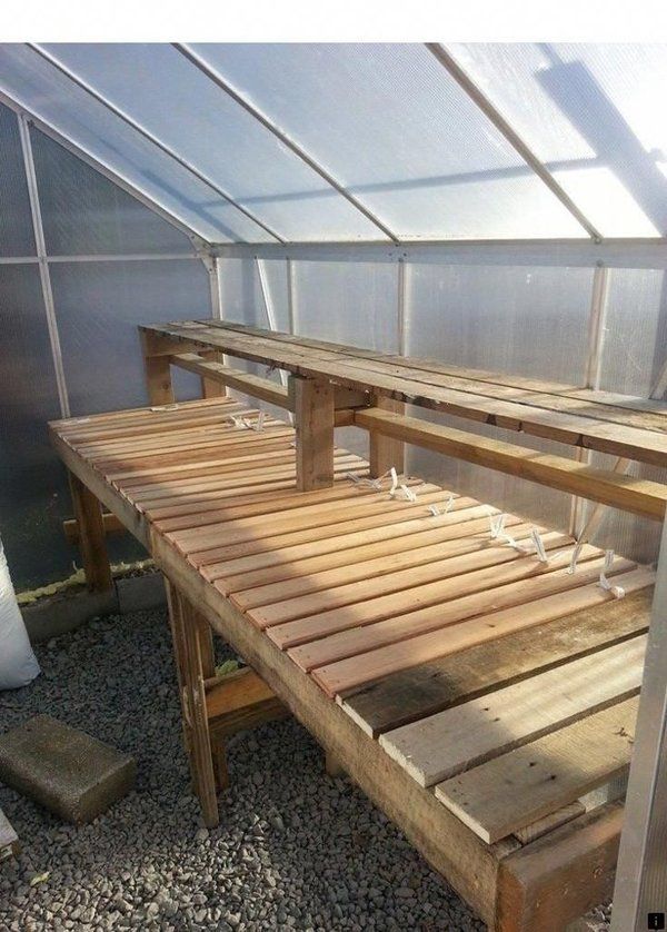 a wooden bench sitting inside of a greenhouse