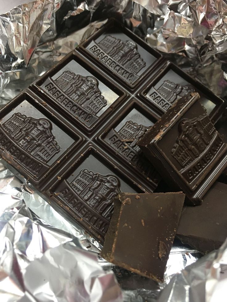 some chocolates are sitting on top of tin foil and have been cut into squares