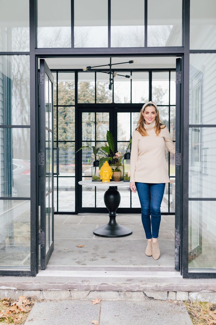 a woman standing in front of a glass door