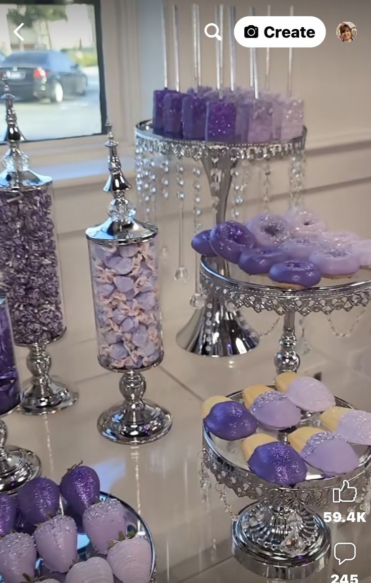 purple and yellow desserts are displayed on three tiered trays