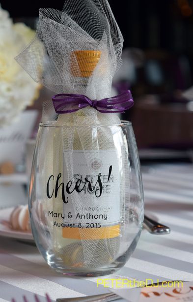 a wine glass filled with cheeses on top of a white table cloth next to utensils