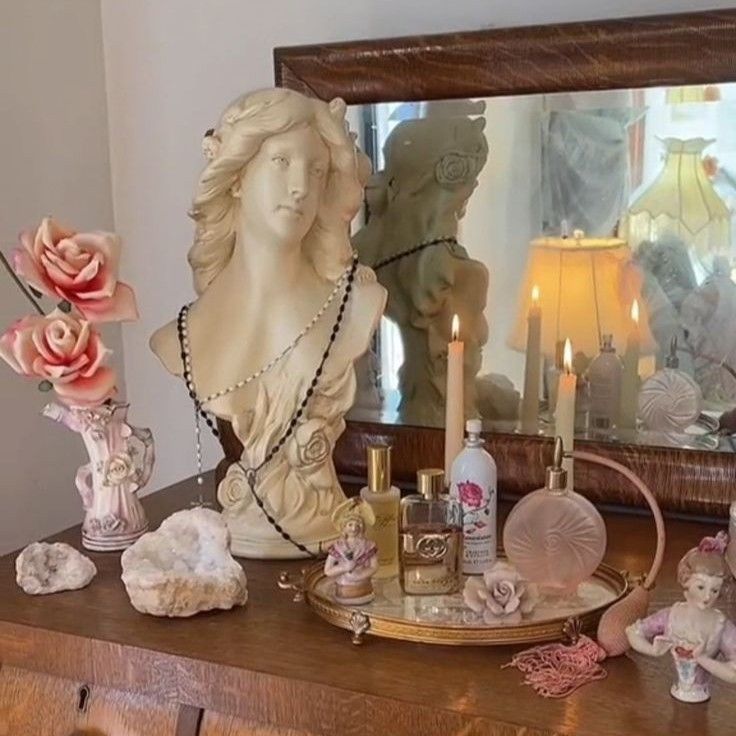 a dresser with candles, figurines and other decorative items on top of it