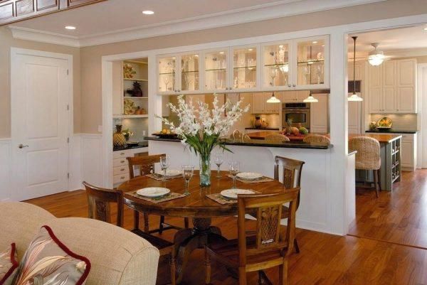 a dining room table and chairs in front of an open kitchen