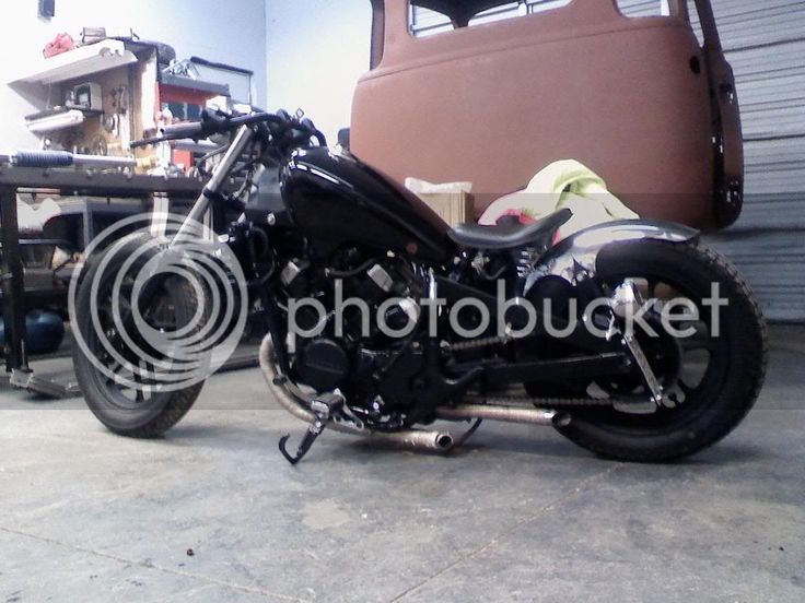 a black motorcycle parked in a garage next to a truck