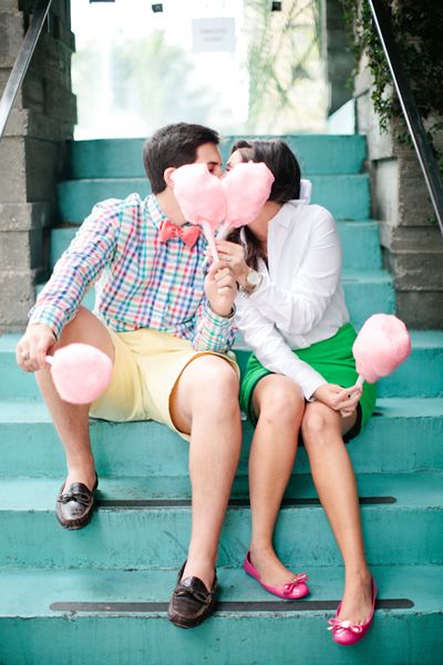 a man kissing a woman on the cheek while sitting on steps with pink pom - poms