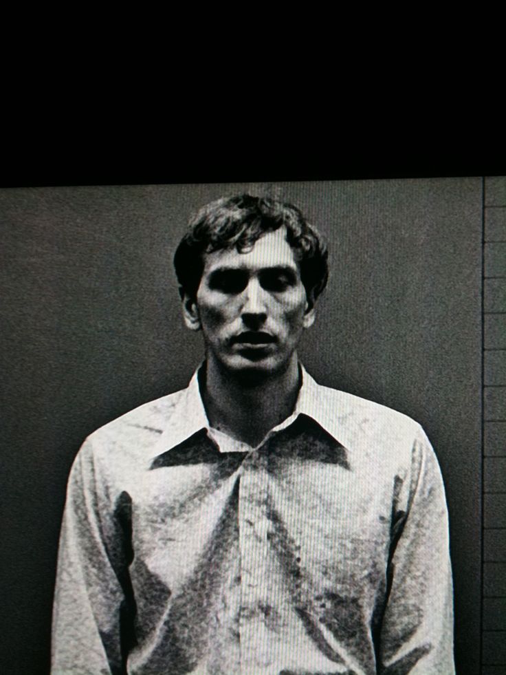 a man standing in front of a black and white photo