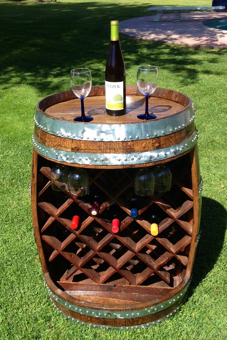 a wooden barrel with two wine glasses on it and a bottle of wine in the middle