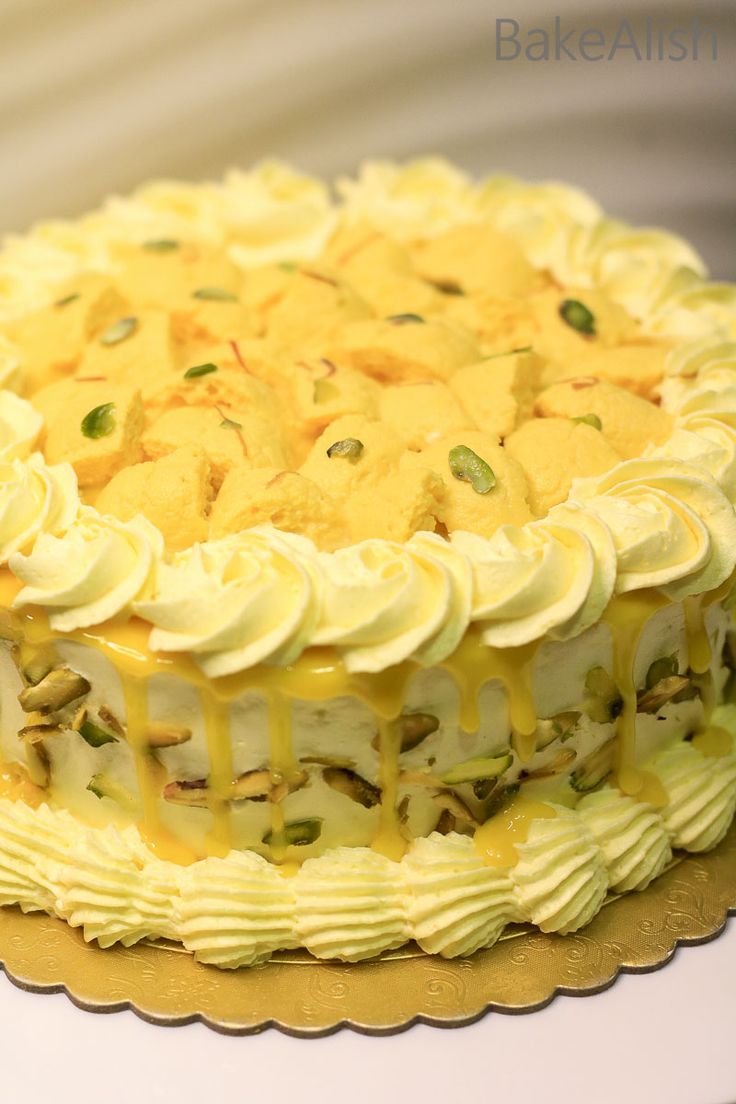 a yellow cake with white frosting and pineapple toppings on a gold plate