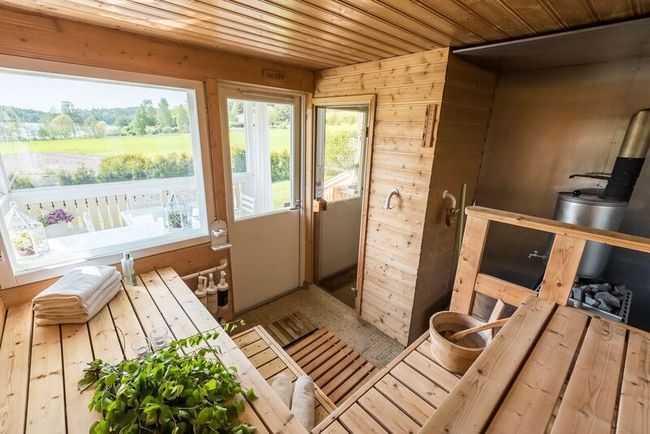 a wooden table sitting inside of a kitchen next to a window and potted plant