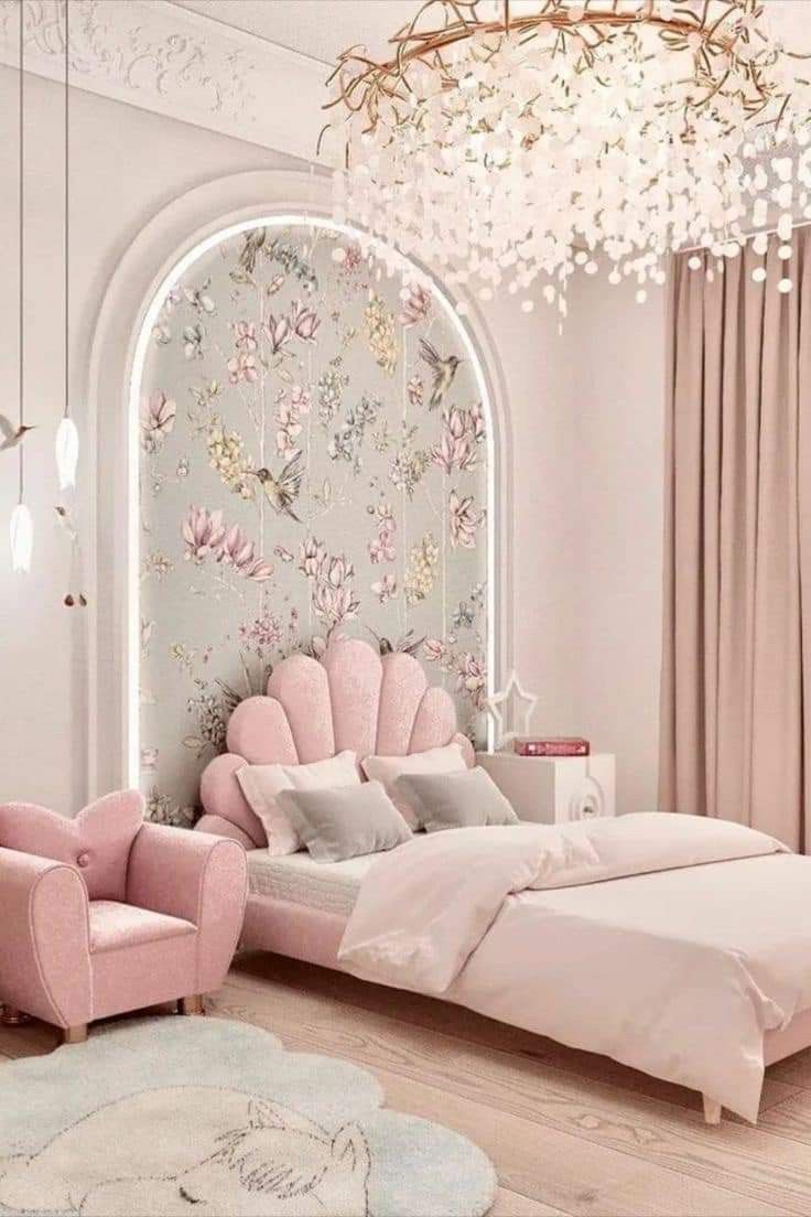 a bedroom decorated in pink and white with a chandelier