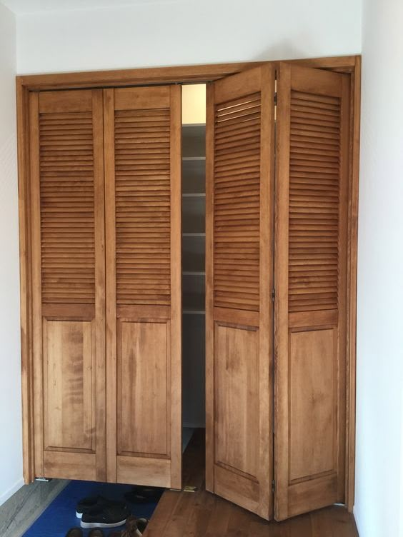 an empty room with wooden shutters on the doors and hard wood flooring in front of it