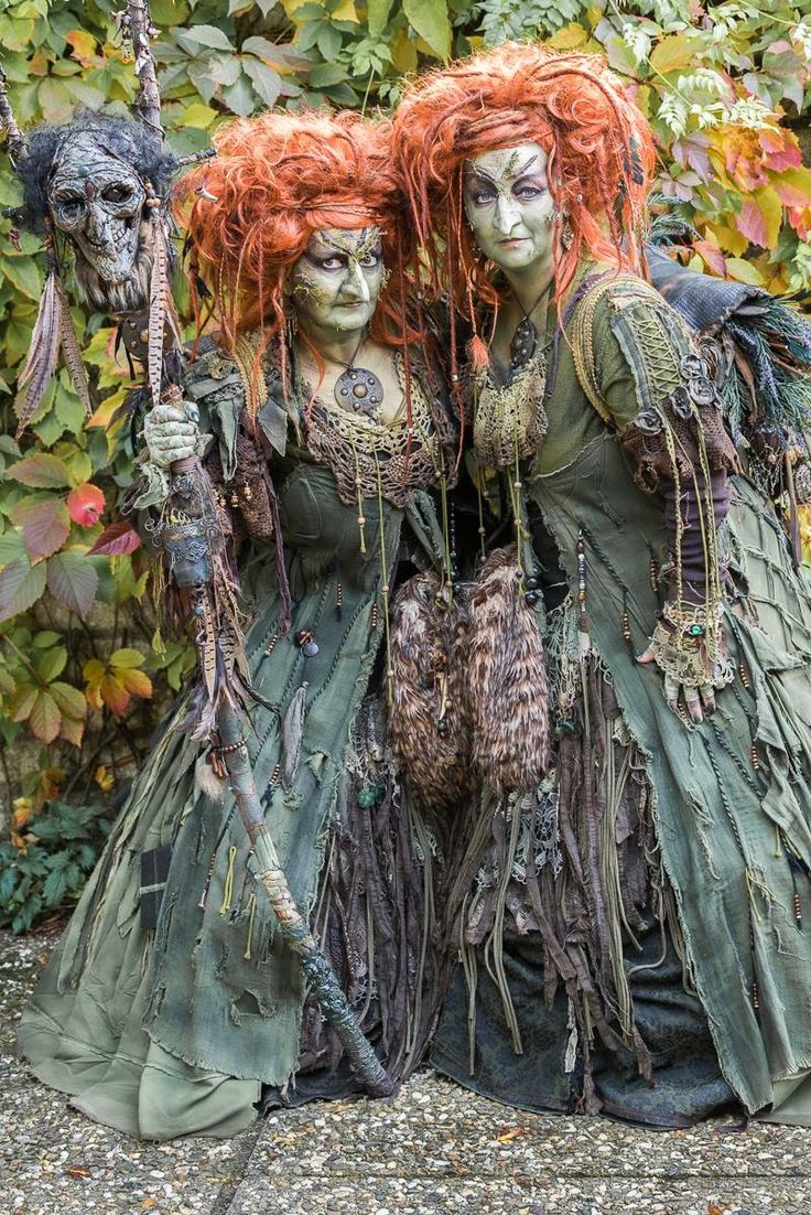 two women dressed in green and orange with red hair are standing next to each other