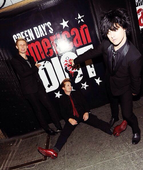 two men in suits and ties standing next to each other near a sign that says mean out