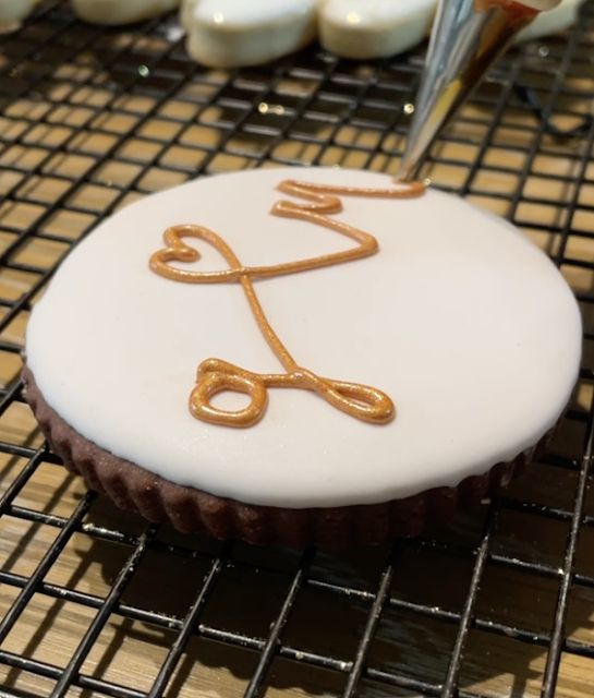 a cupcake that has been decorated with icing and some scissors on top of it