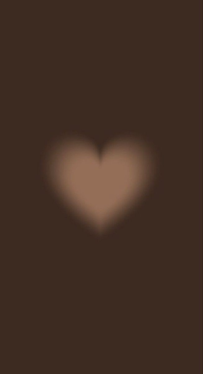 the shadow of a heart on a dark brown background is seen in this image, it appears to be blurry