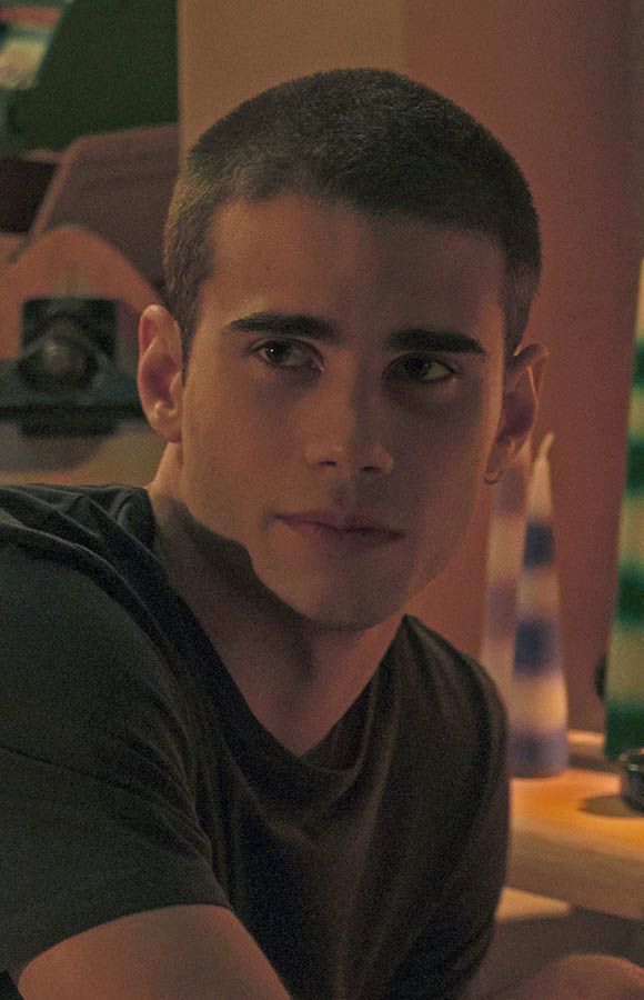 a young man sitting in front of a laptop computer