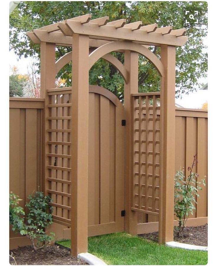 a wooden gate in the middle of a yard