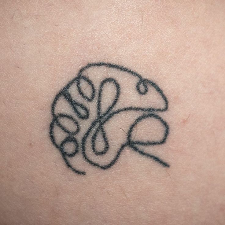 a tattoo on the back of a woman's shoulder with a snake in it