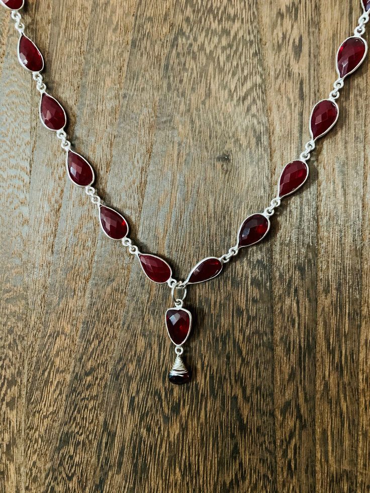 "Metal is silver plated brass. Necklaces can be adjusted to be made shorter upon request.  Necklace length is 18.5 \"  Healing properties of this necklace: Ruby Quartz: Ruby Quartz activates and balances the base and heart chakras. It is a crystal of passion, wisdom and vitality. Ruby Quartz eases the path of transformational change from survival to creation. Garnet:  The garnet revitalizes, purifies and balances energy, bringing serenity or passion as appropriate. Inspires love and devotion. It activates and strengthens the survival instinct, bringing courage and hope." Silver Adjustable Teardrop Crystal Necklace, Silver Adjustable Teardrop Crystal Necklaces, Adjustable Silver Drop Crystal Necklace, Silver Adjustable Drop Necklaces, Silver Drop Spiritual Necklace, Silver Drop Necklace With Spiritual Style, Spiritual Silver Drop Necklace, Adjustable Faceted Silver Necklace, Sterling Silver Teardrop Pendant Necklace With Stones