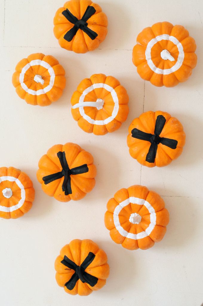 orange pumpkins with black bows are arranged on a white surface, including one for the letter c