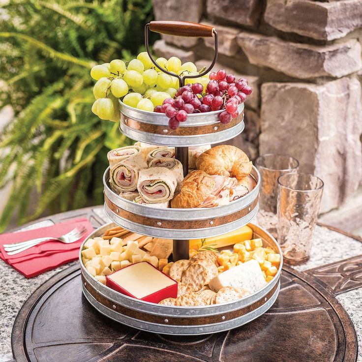 three tiered trays filled with different types of food on top of a table