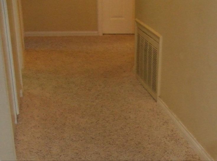 an empty hallway with a heater and fan on the wall in front of it