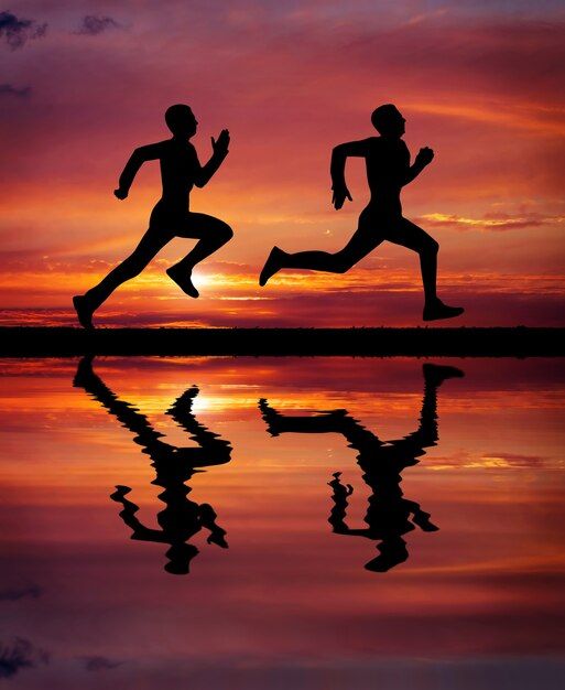 two people running across a body of water at sunset