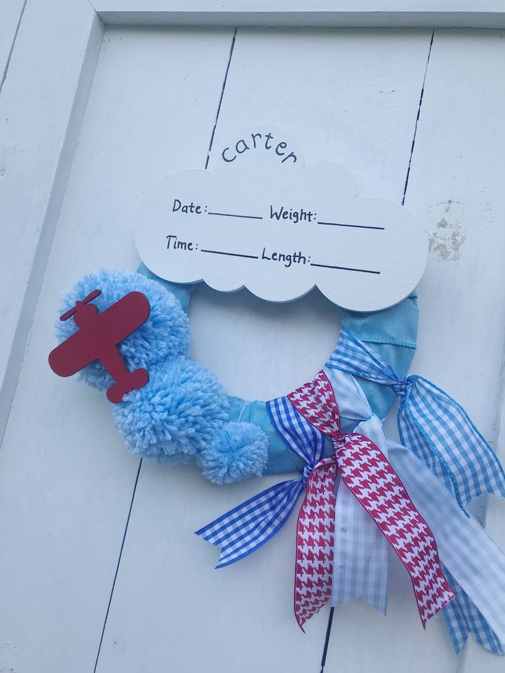 a blue wreath with a red airplane on it and some ribbons tied around the edges