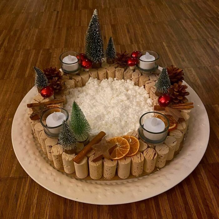 a cake decorated with candles, orange slices and pine cones