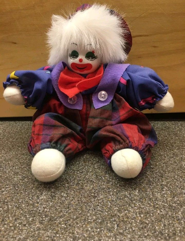 a clown doll is sitting on the floor