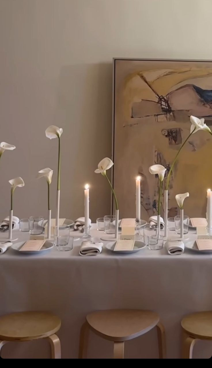 the table is set with white flowers and candles