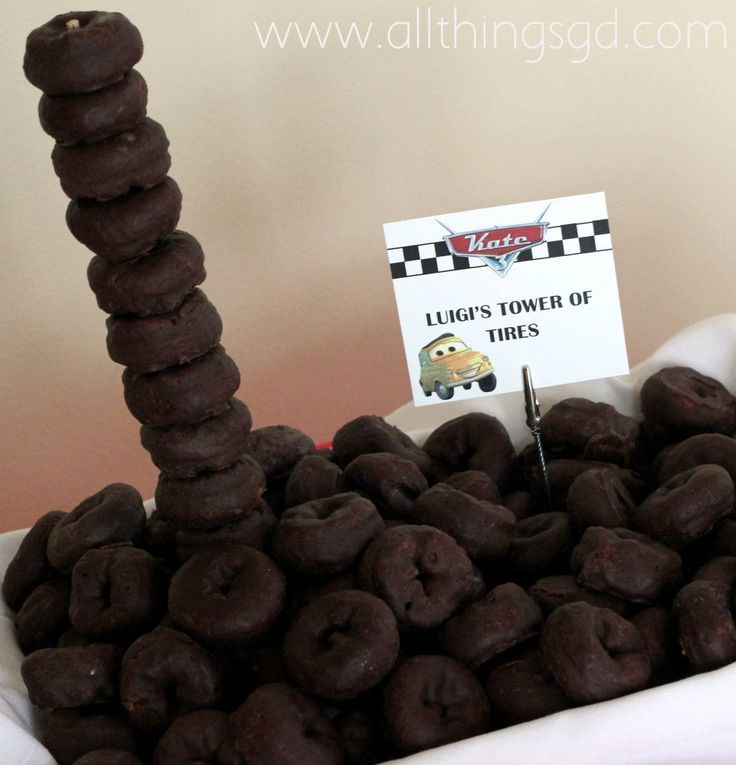 chocolate donuts stacked on top of each other in a bowl with a sign that says lucky's tower of tires