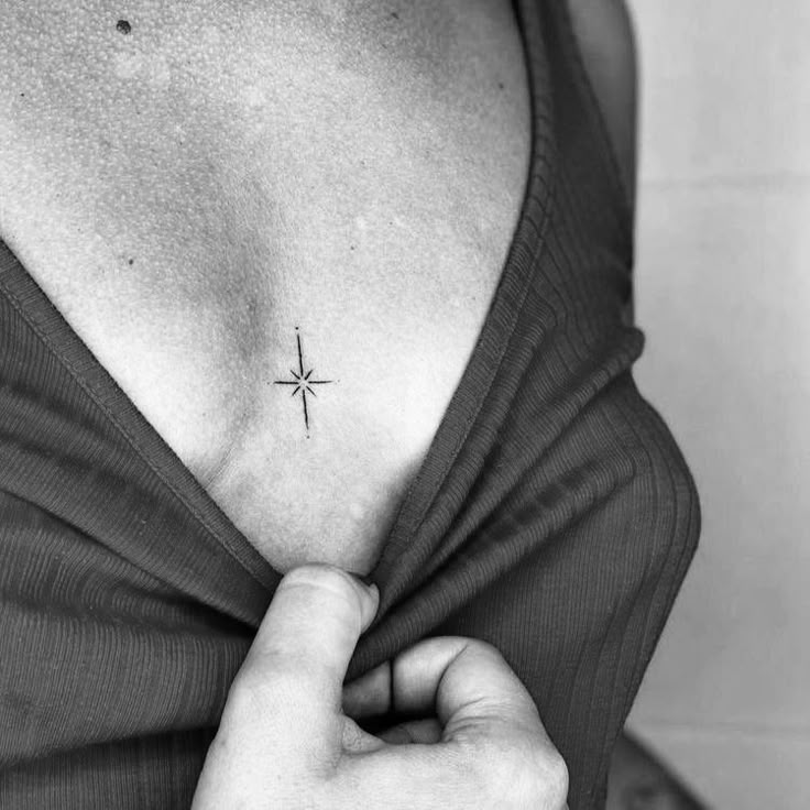 a woman with a small cross tattoo on her chest