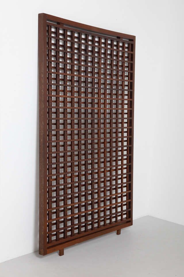 a wooden screen is hanging on the wall in front of a white wall and floor