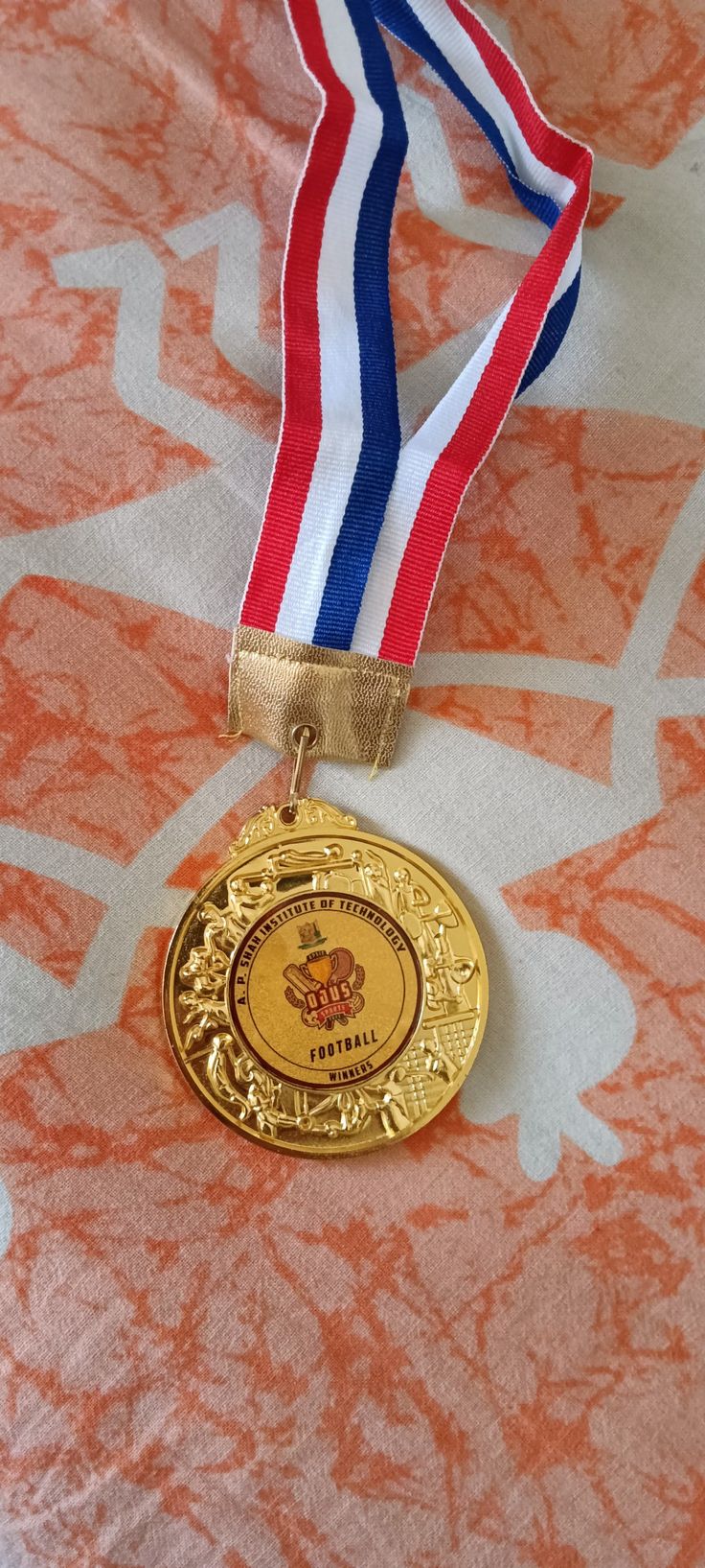 a gold medal with a red, white and blue ribbon around it's neck