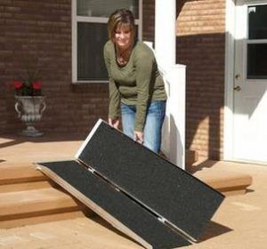 a woman standing next to a black piece of furniture on the ground in front of a house