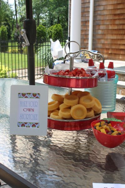 three tiered trays filled with donuts and fruit on top of a table