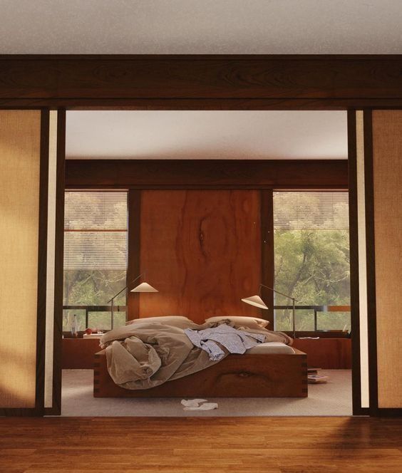 a bed sitting inside of a bedroom on top of a hard wood floor next to a window