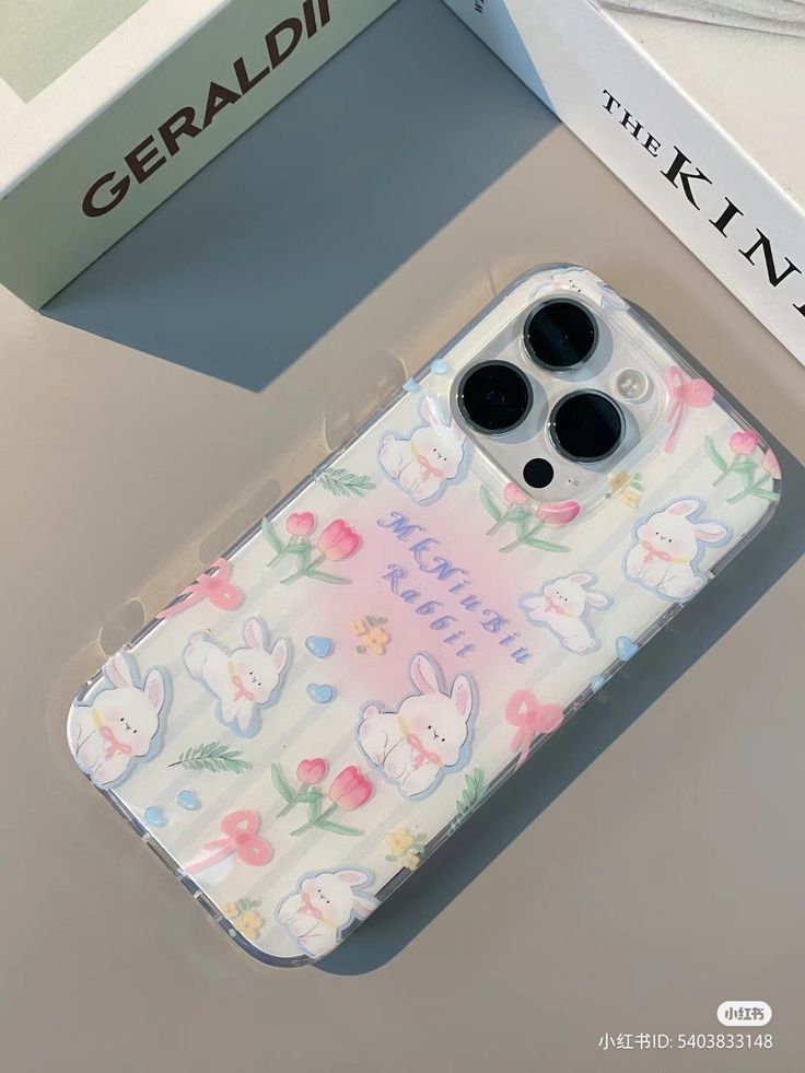 an iphone case with bunny and flowers on it next to a box that says geradii