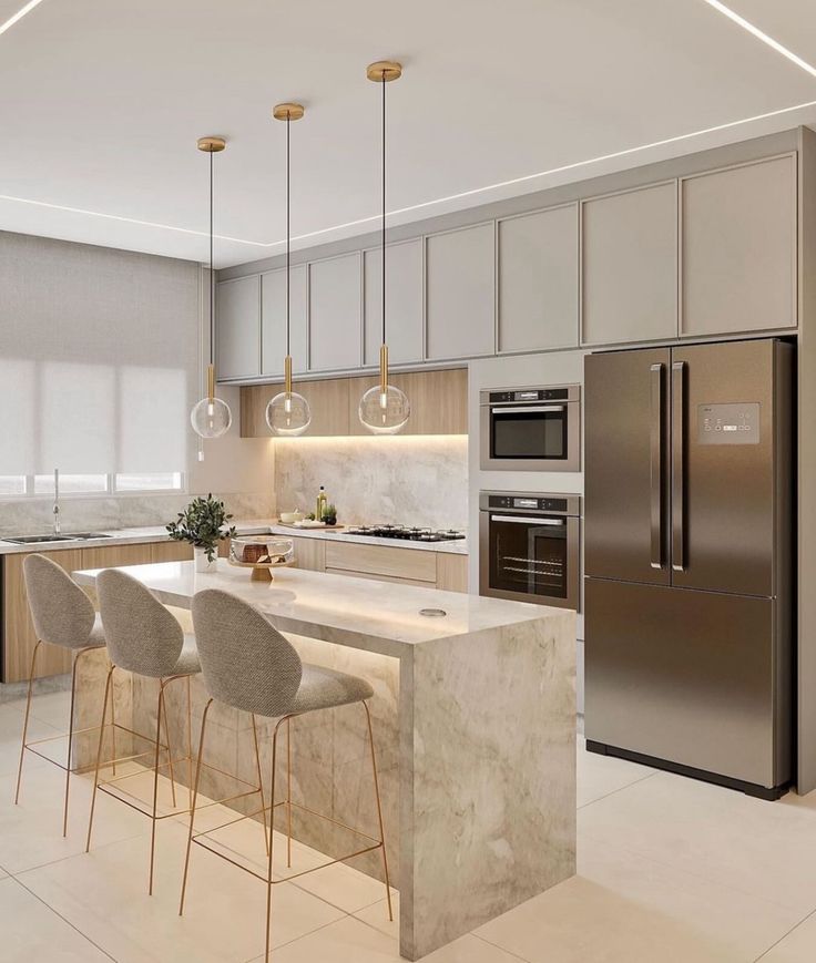 a modern kitchen with stainless steel appliances and marble counter tops, along with bar stools