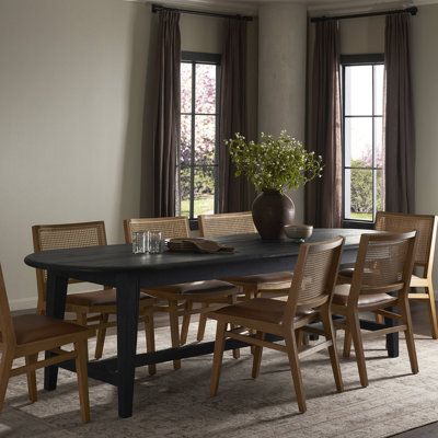 a dining room table and chairs in front of two windows