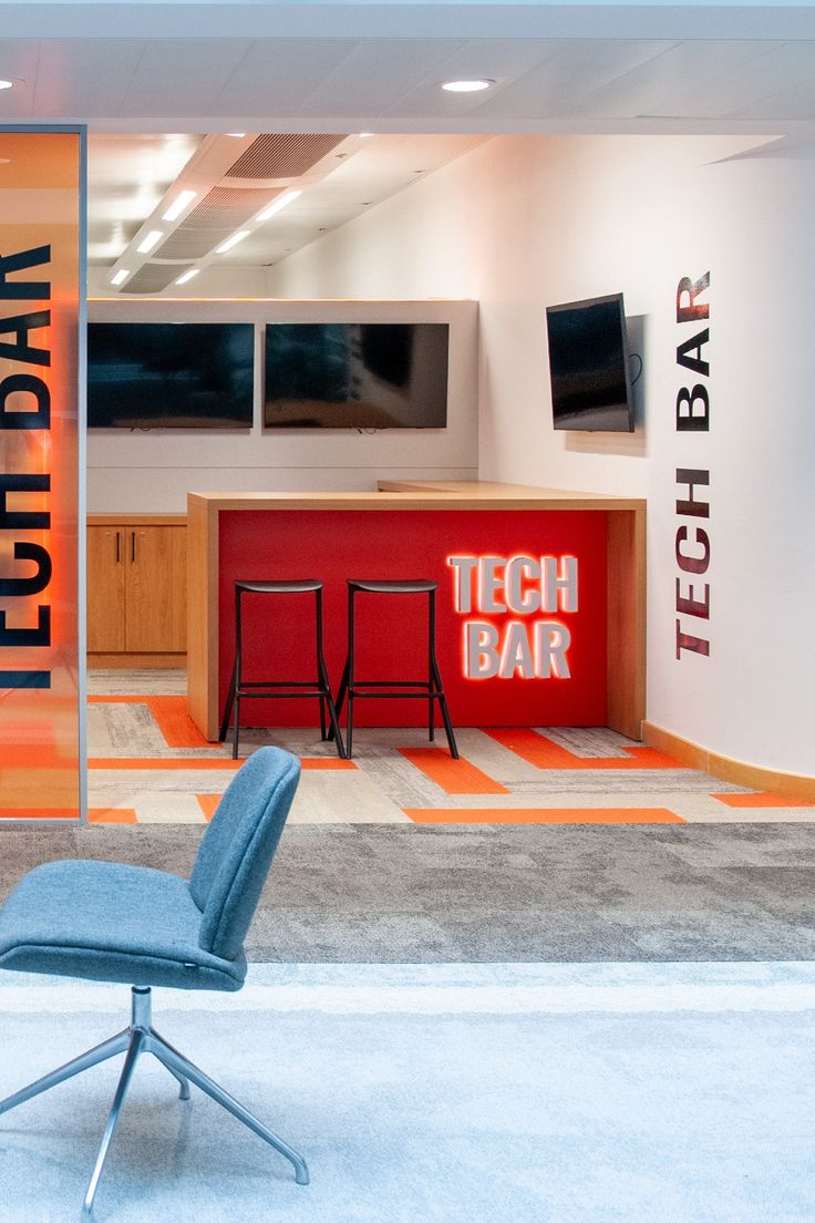 a blue chair sitting on top of a carpeted floor next to a red sign