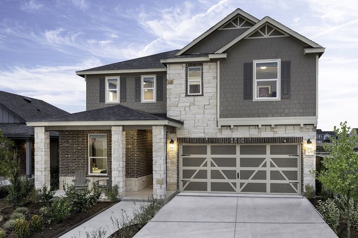 a two story house with a garage in the front yard