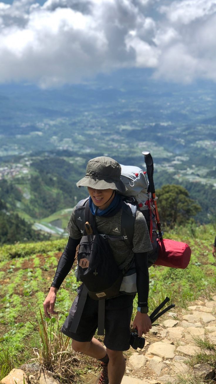 a man hiking up the side of a mountain with a backpack on his back,