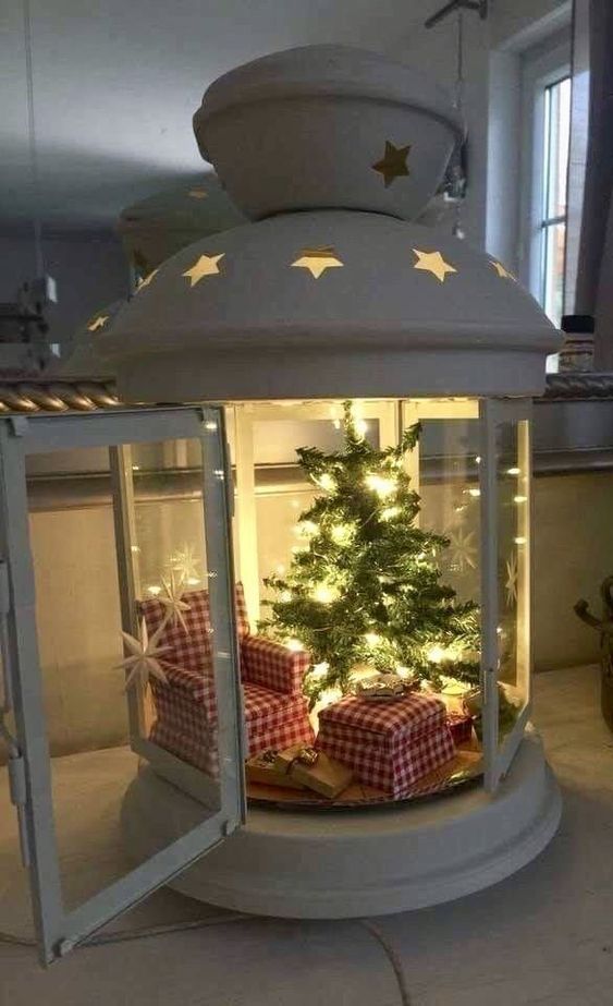 a christmas tree in a glass case with presents under the top and lights around it