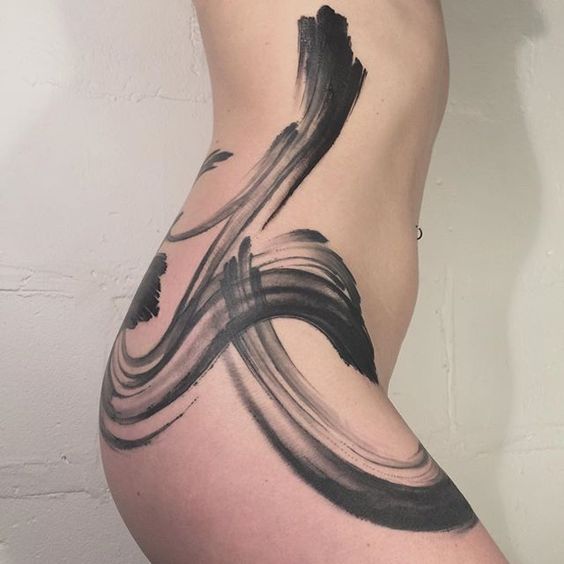 a woman's lower body with black and grey ink art work on the side