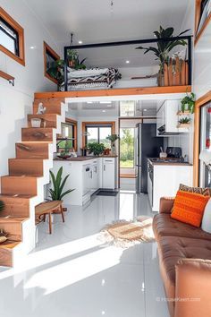 a living room filled with furniture next to a kitchen and dining area on top of stairs