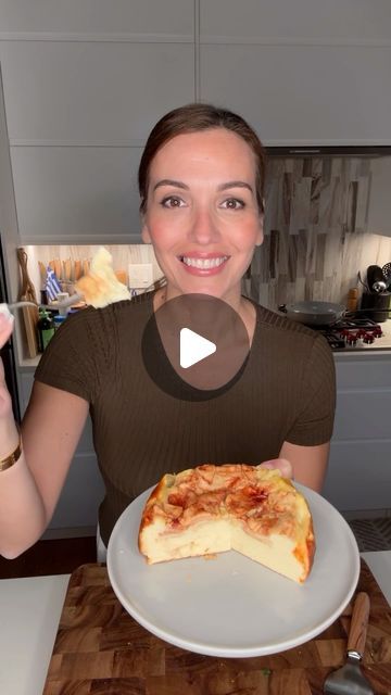 a woman holding up a plate with pizza on it