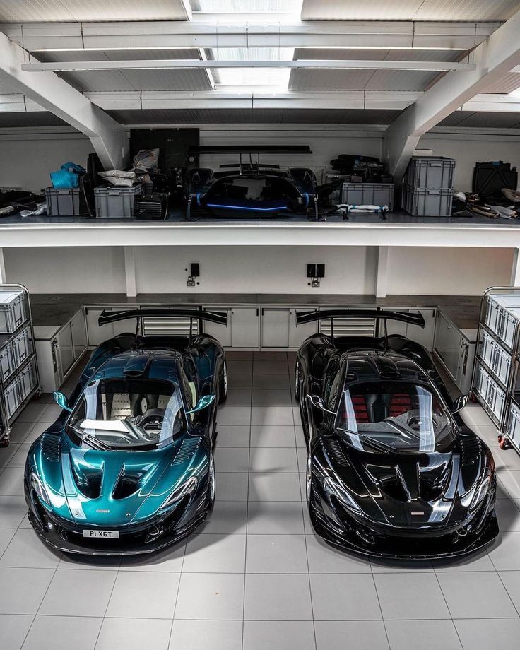 two sports cars parked in a garage next to each other